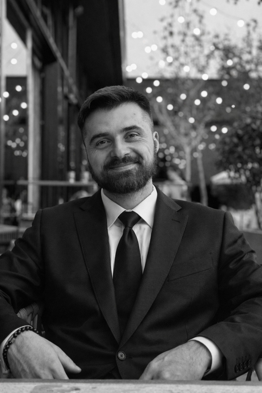 Smiling person in a jacket with arms crossed, black and white photo