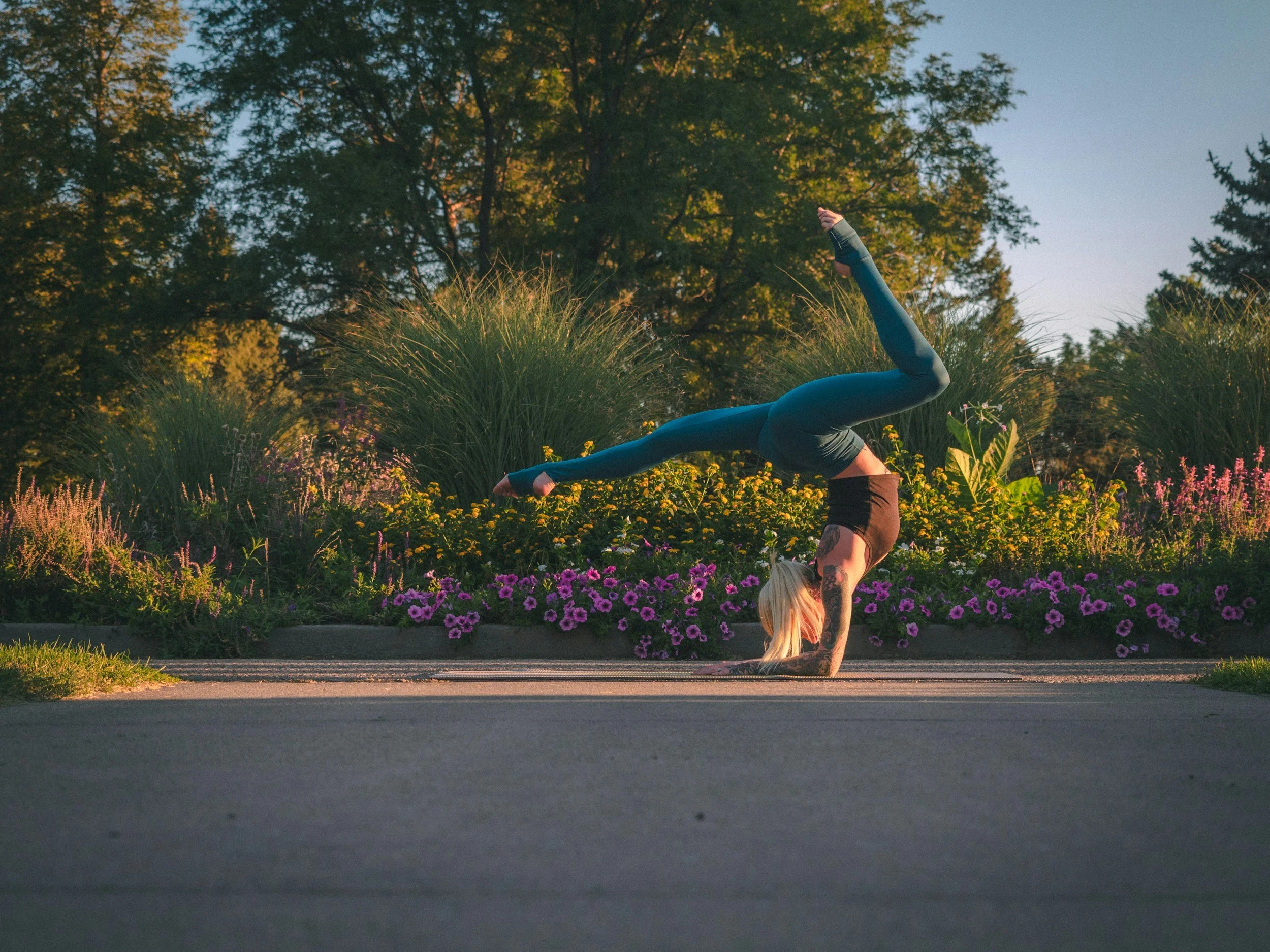 A woman with blonde hair doing a headstand yoga pose outdoors. Find compassionate support with eating disorder therapy for athletes in NJ.