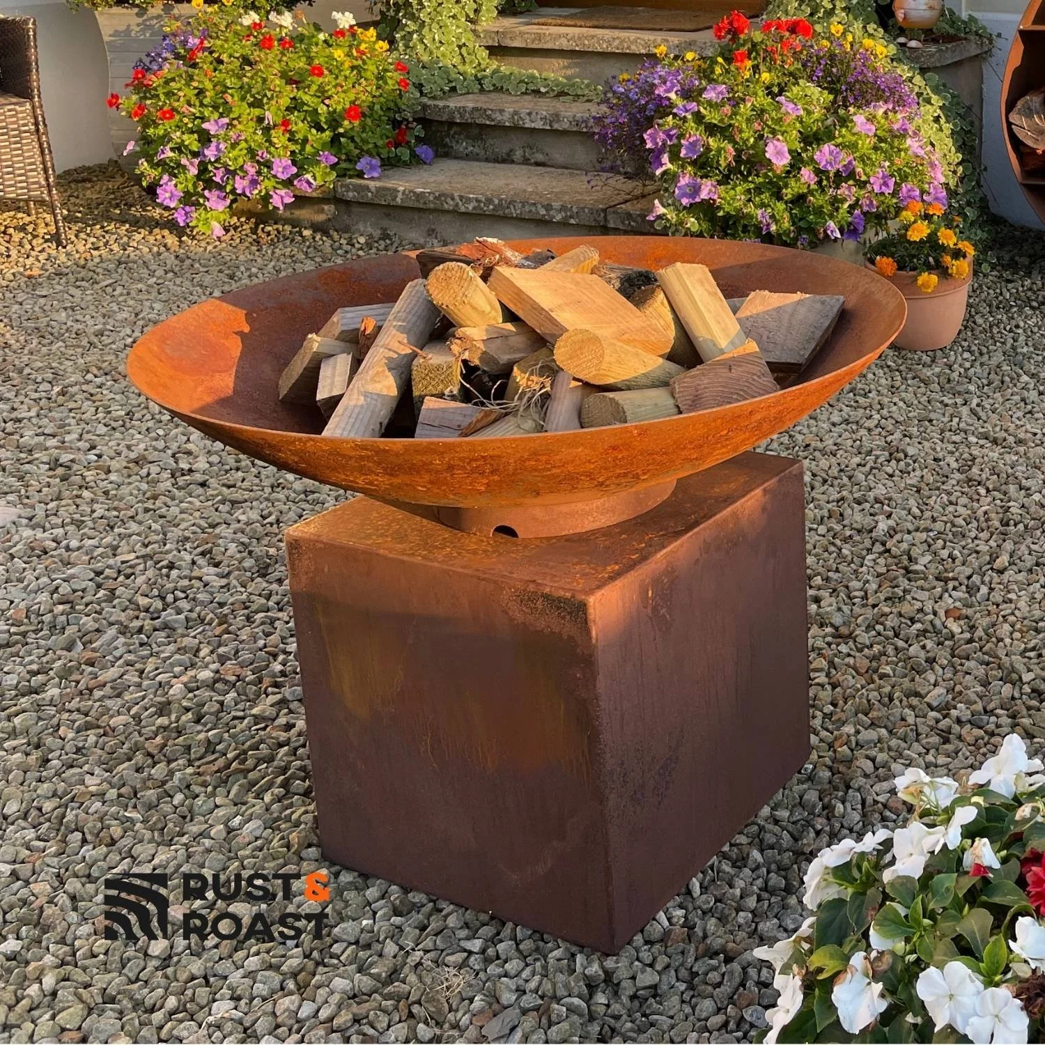 Modern steel fire bowl on a corten steel pedestal for outdoor gardens