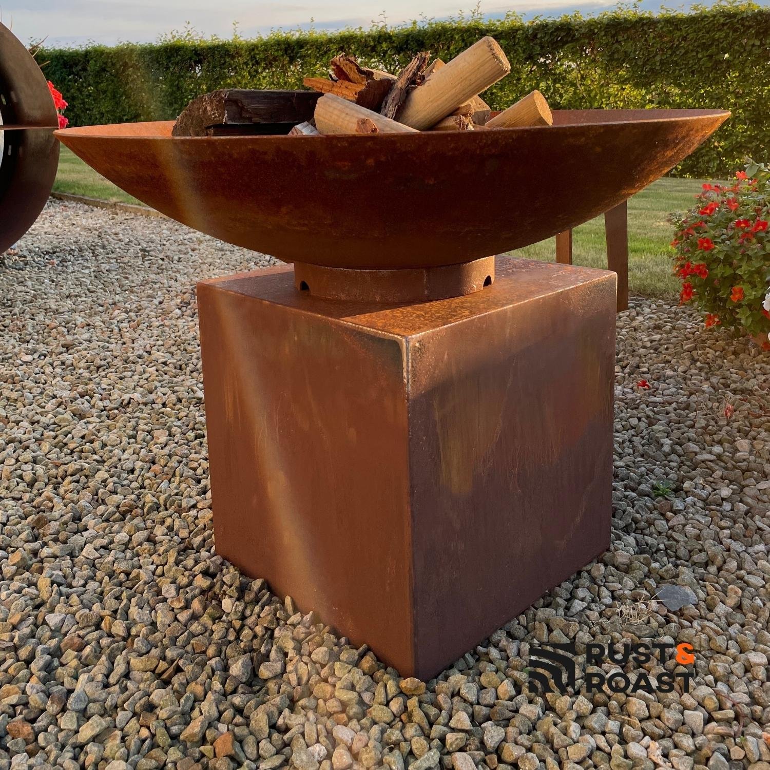 Modern steel fire bowl on a corten steel pedestal for outdoor gardens