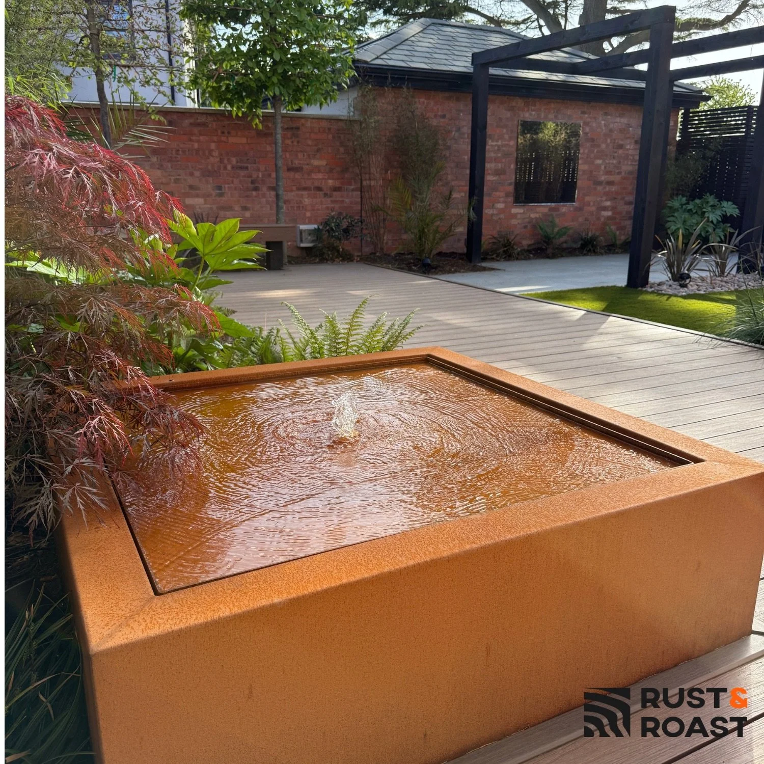 Corten steel water table with integrated LED light in a contemporary garden