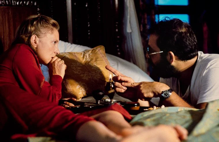 Behind the scenes: Aurore Clement listening attentively to Francis For Coppola before the opium scene with Martin Sheen.