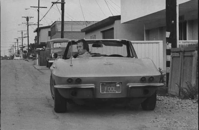 David Carradine in his Corvette “FOOL” in front of his beach house in Malibu. (1975)