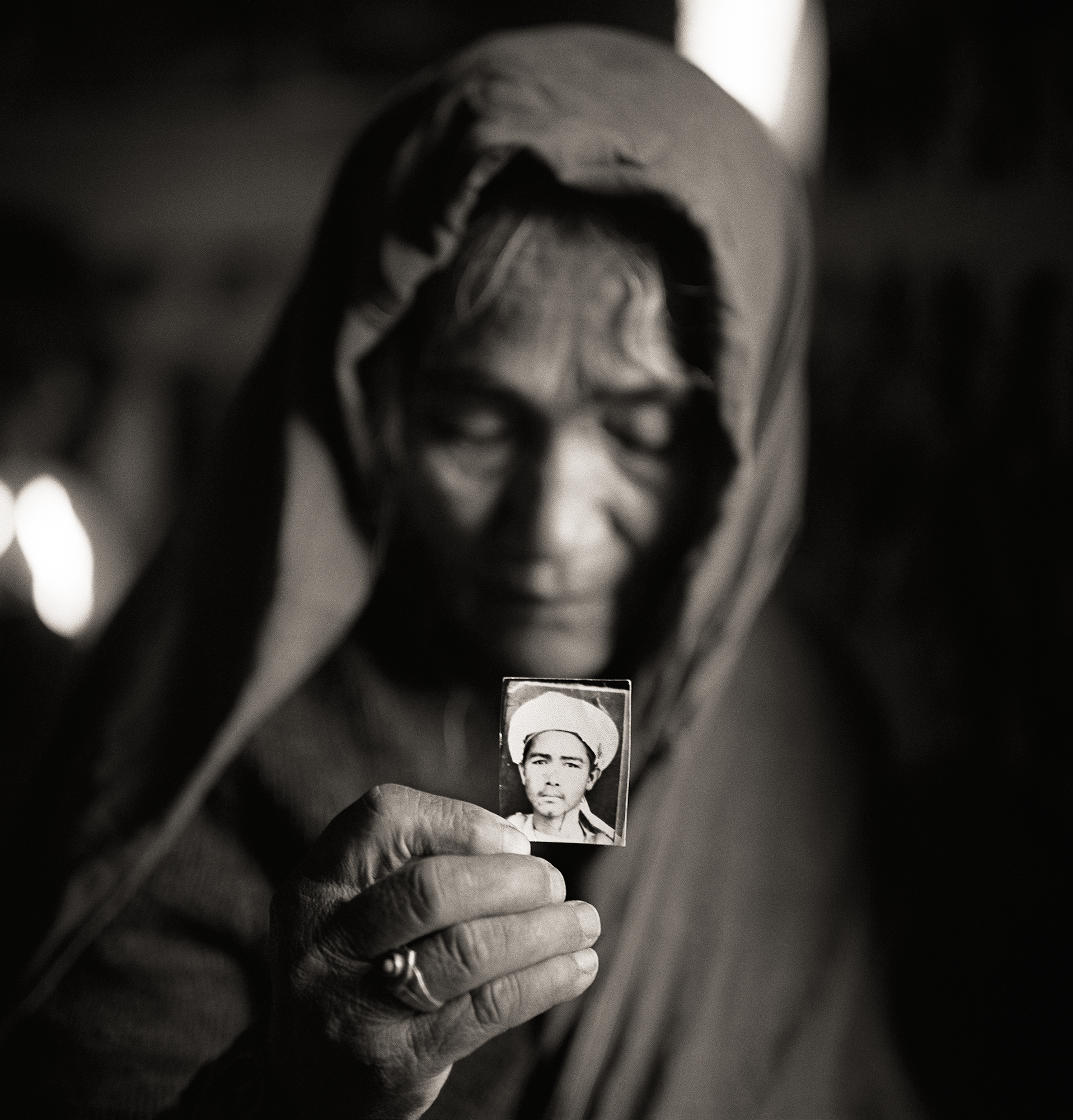Qurban Gul Holding a Photograph of Her Son Mula Awaz, Khairabad, Northern Pakistan, 1998 © Fazal Sheikh