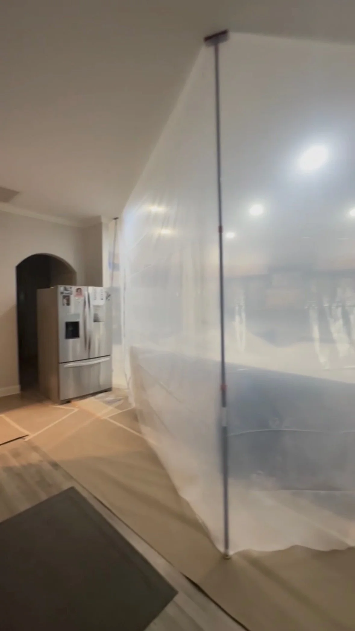 Plastic containment spray booth setup for cabinet painting in Nashville kitchen