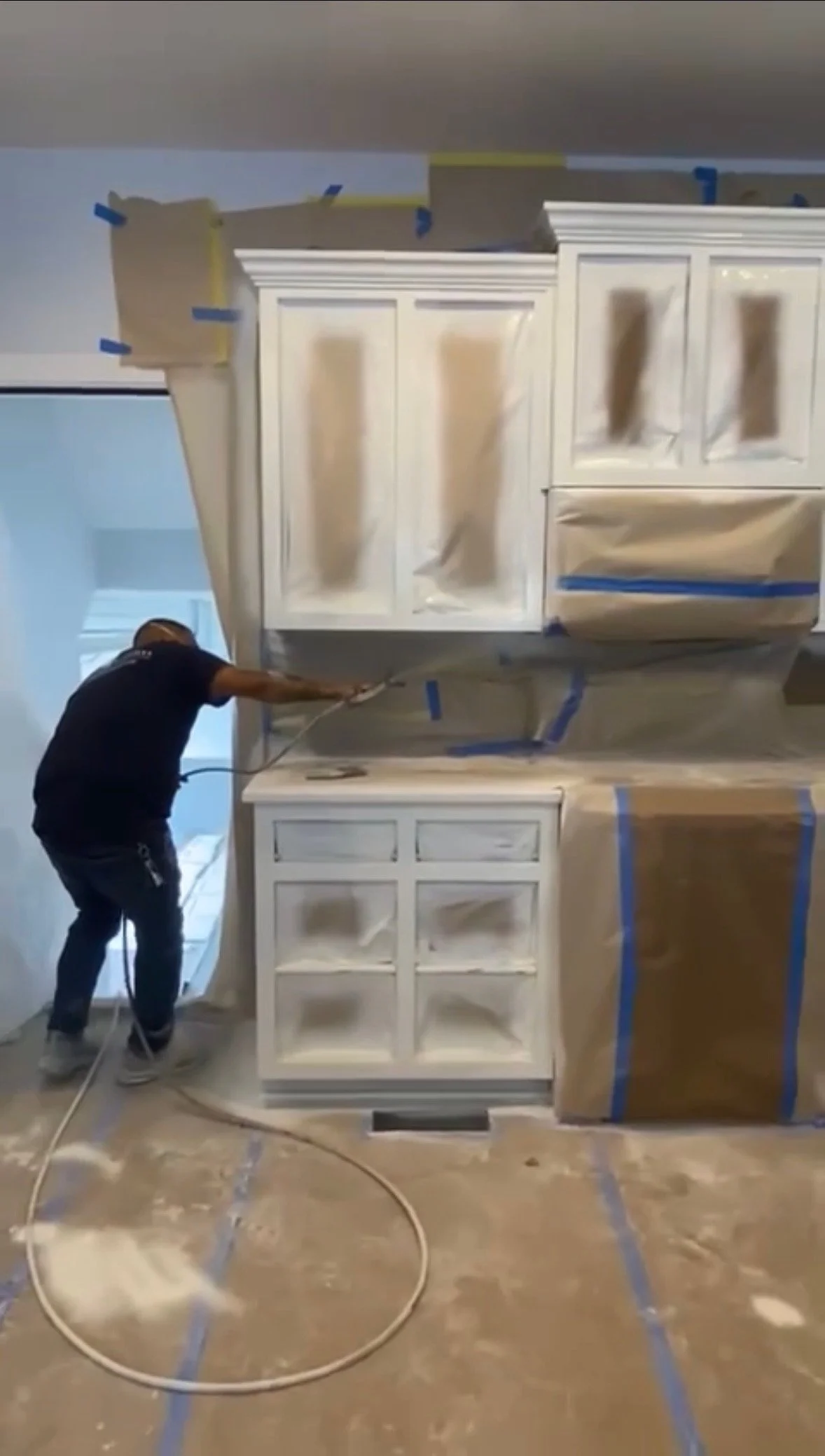 The House Painters crew spray painting white kitchen cabinets in Nashville