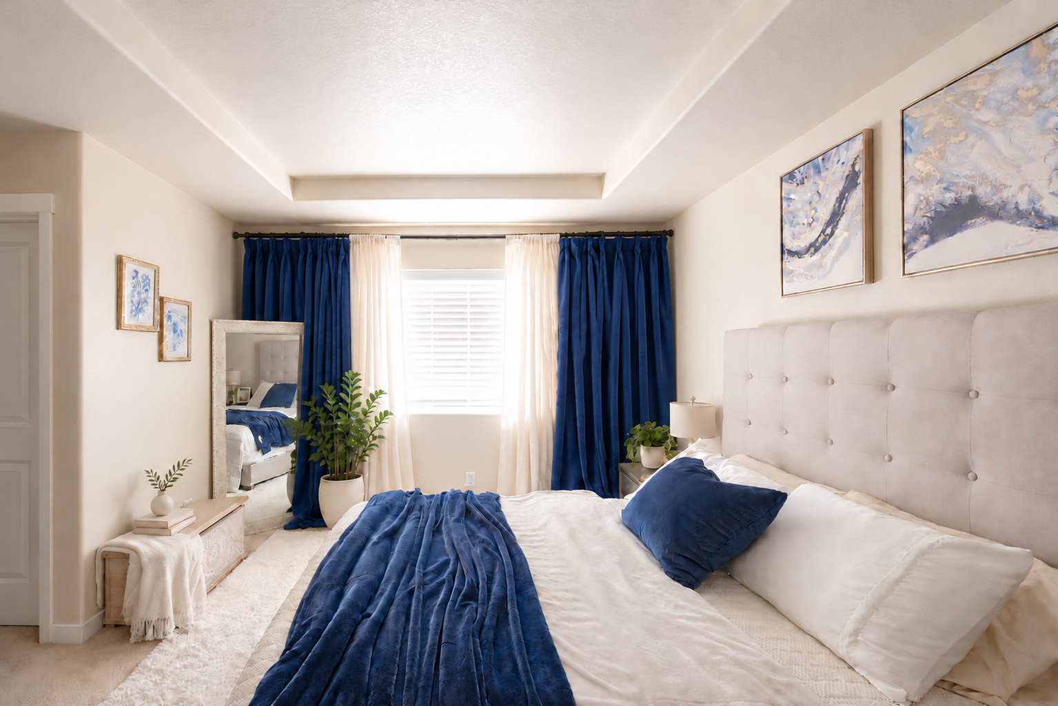 Luxurious navy drapes frame a bright bedroom (1).png