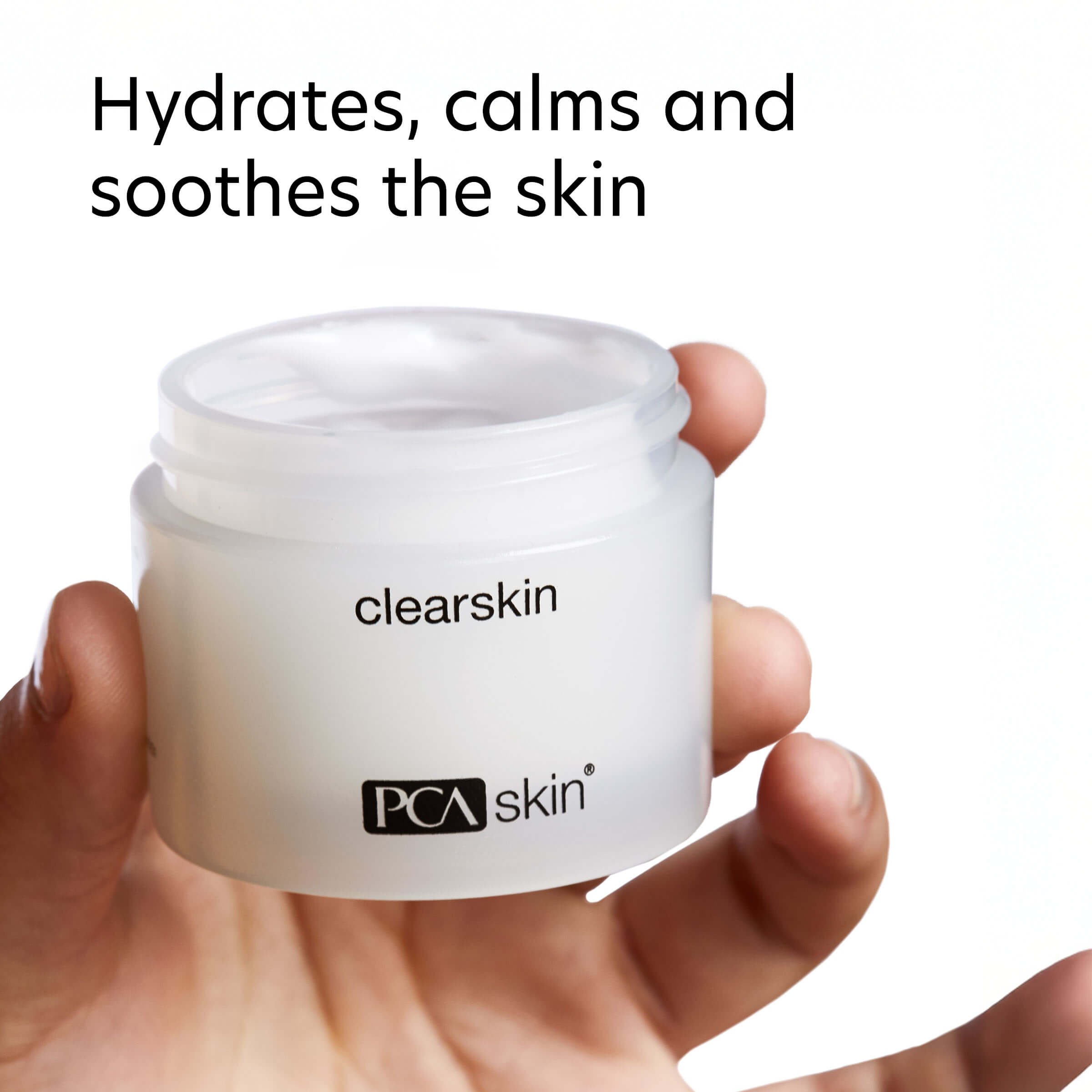 Open jar of PCA Skin Clearskin held in hand, showing light, creamy texture of the moisturizer for breakout-prone skin.