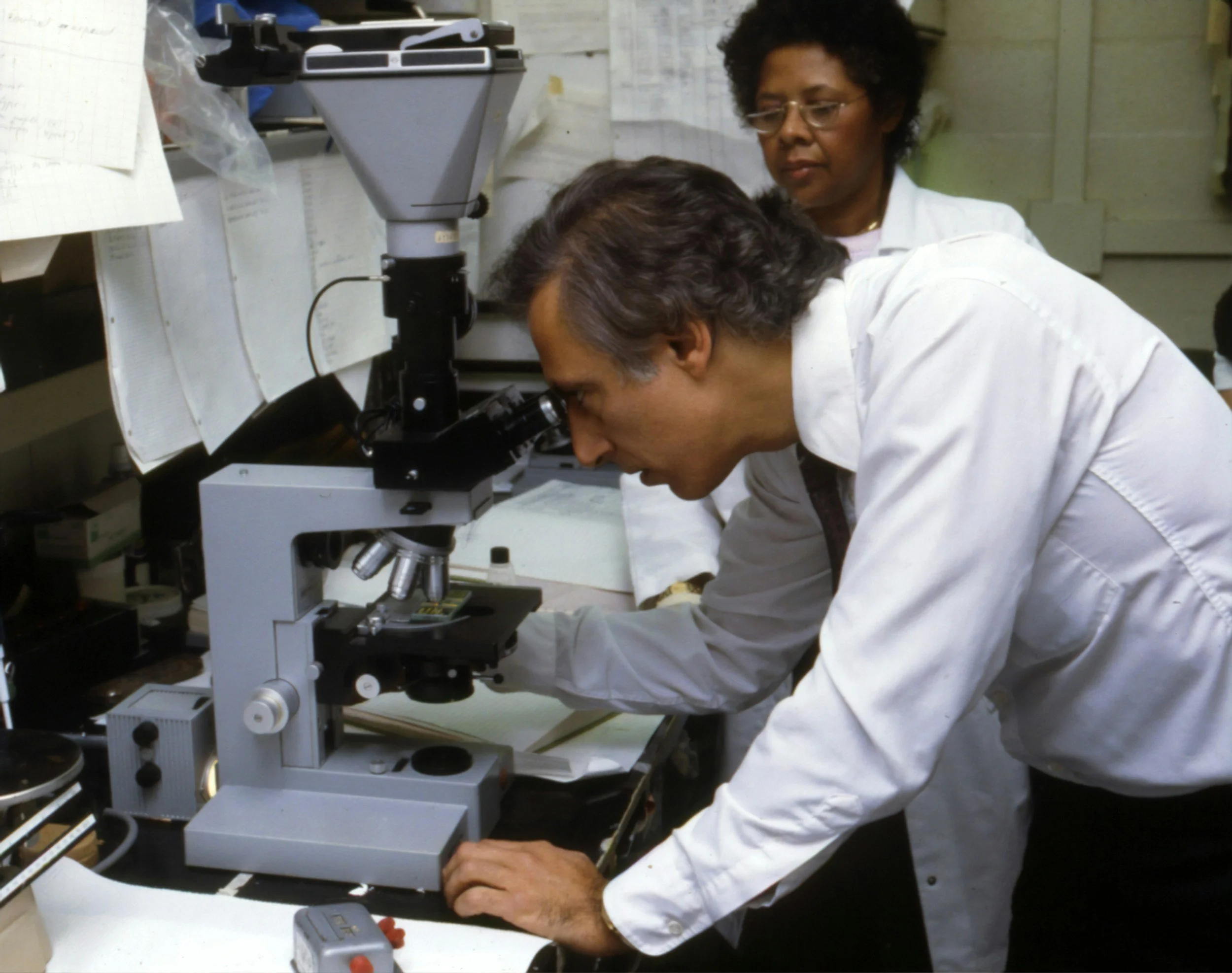 Researcher using a microscope, representing scientific inquiry and research methodologies.