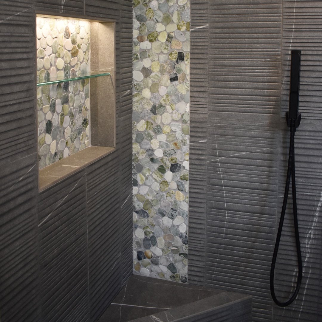 Step into luxury. The shower in the Hygia Coastal Retreat features sleek fixtures and beautiful tile work for a relaxing, spa-like experience. ⁠
⁠
&mdash;&mdash;⁠
⁠
#baworthing #bathroominspo #interiordesigner #renovation #remodel #bathroomdecor