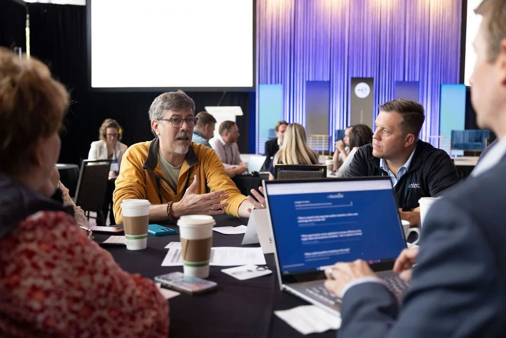 Attendees in conversation around a table during an eSummit roundtable session