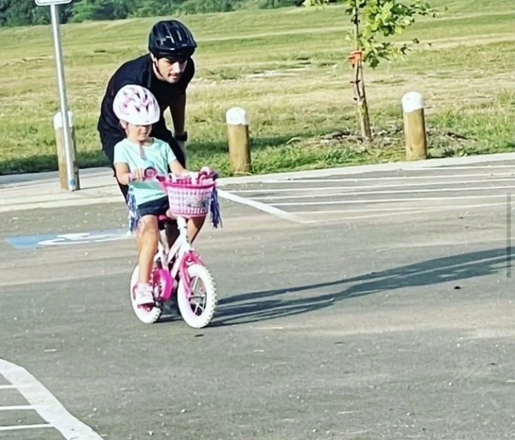 Young girl riding a pink pedal bike