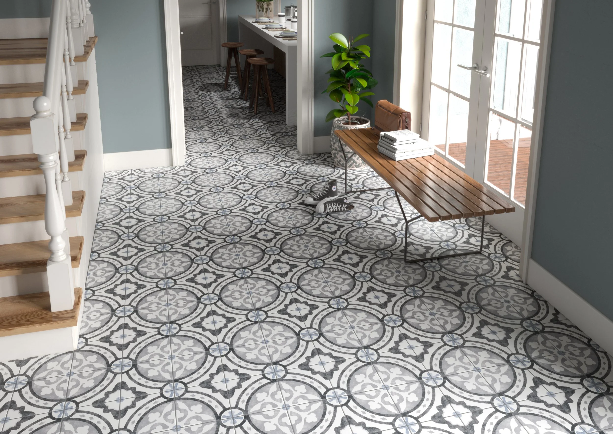 Interior view of a room with patterned tile flooring, a wooden table, and a large window with a door leading outside. There is a potted plant and a telephone on the floor.