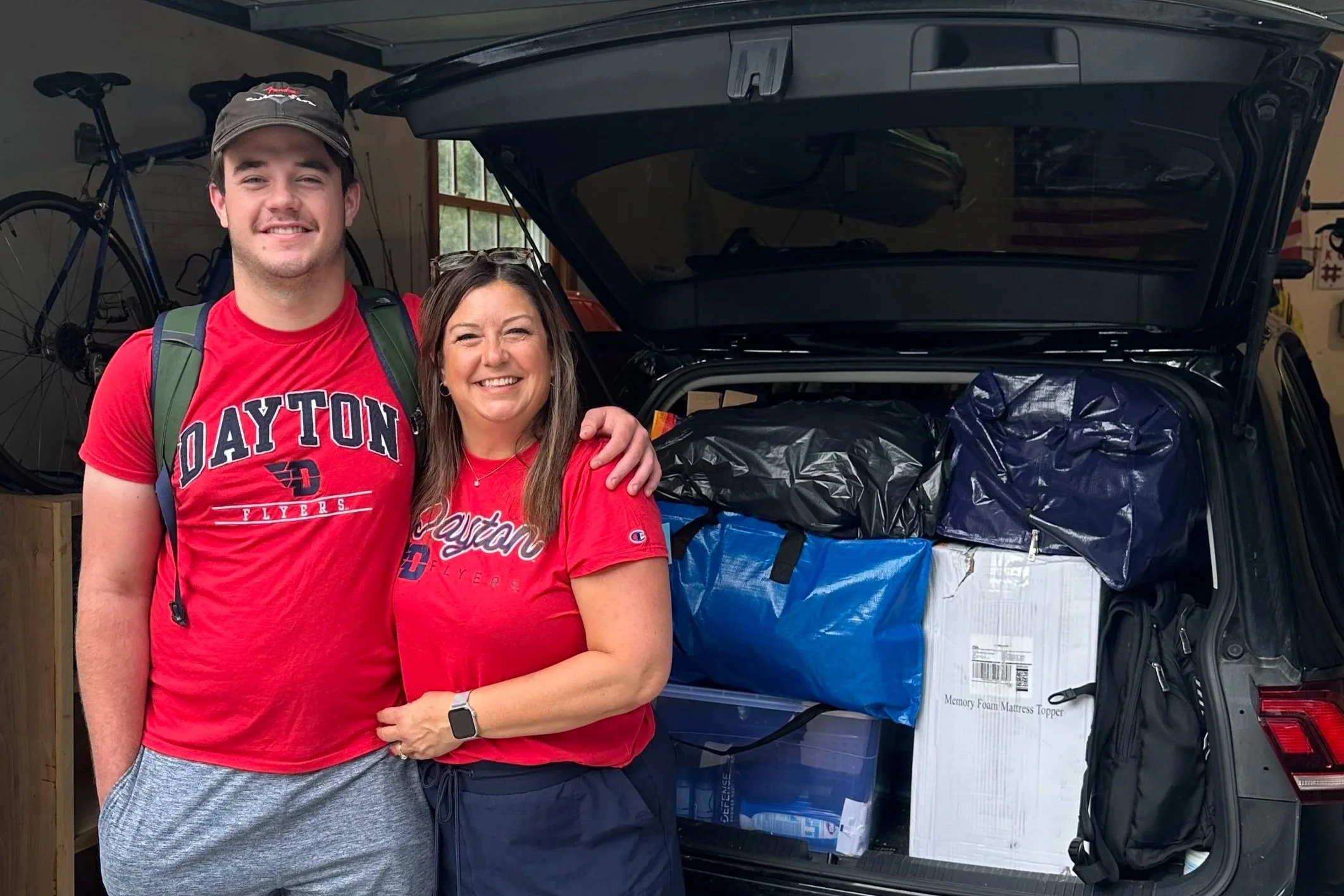 Liz and her son Tommy pose before returning to his off-campus house for another year of college, reflecting on the financial decisions families make during the college years.