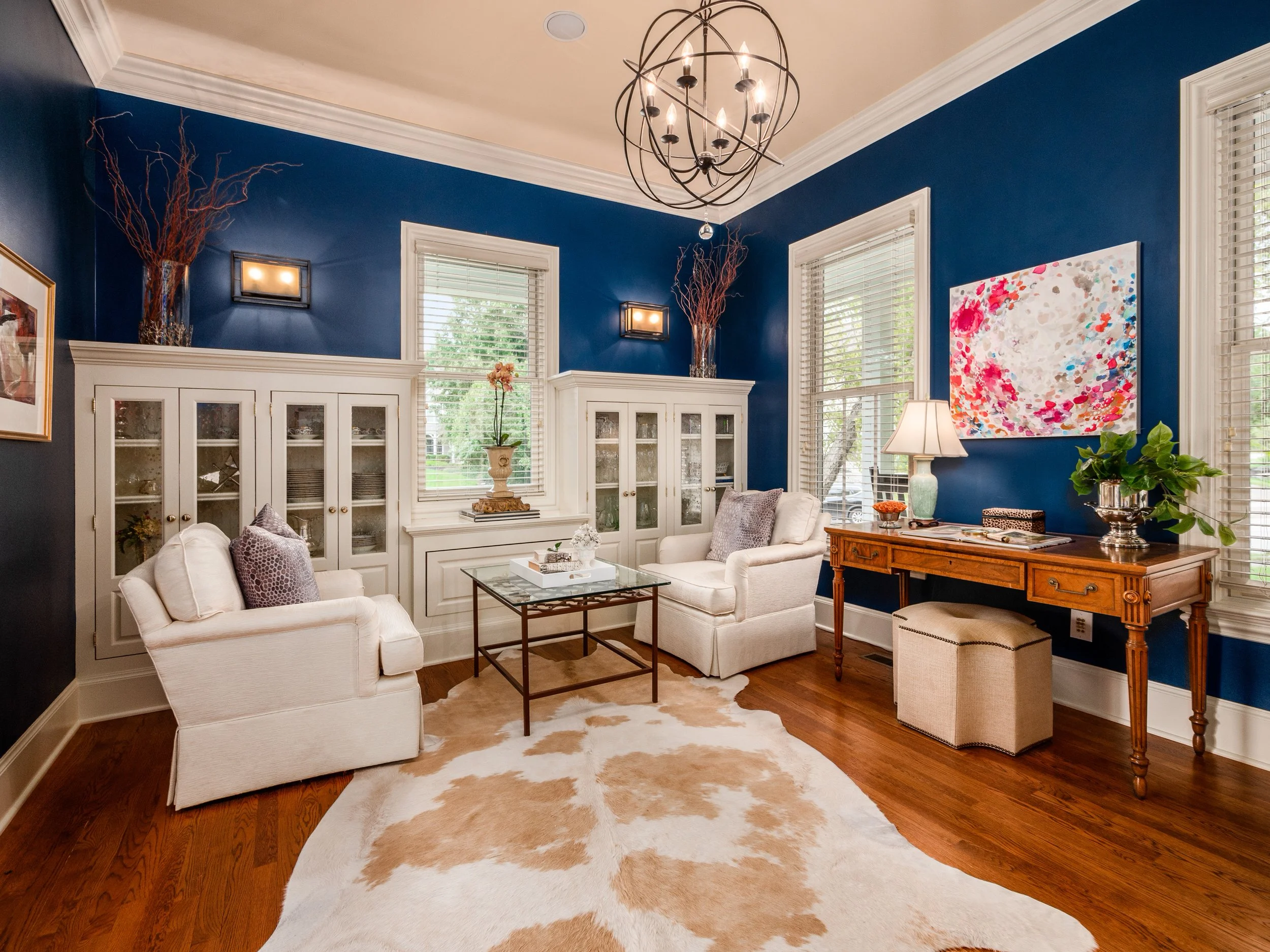 stunning white built-in cabinetry and gorgeous wide custom millwork contrast beautifully with the dramatic deep blue walls, greeting visitors to this home with an instant WOW!