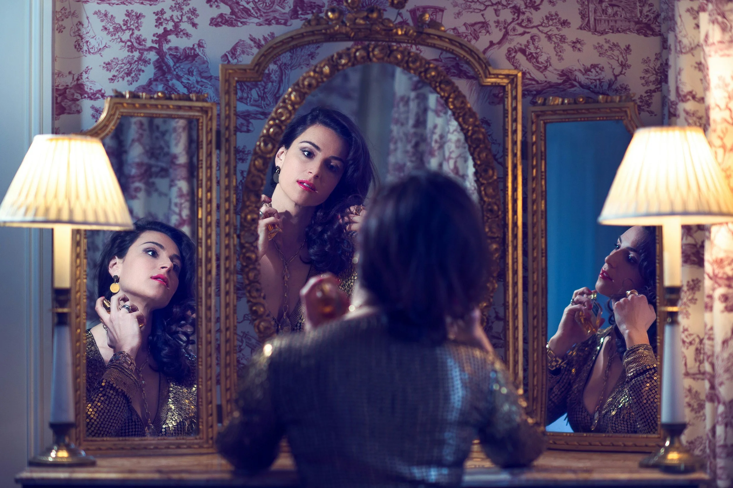 woman looks at her reflection in 3 mirrors