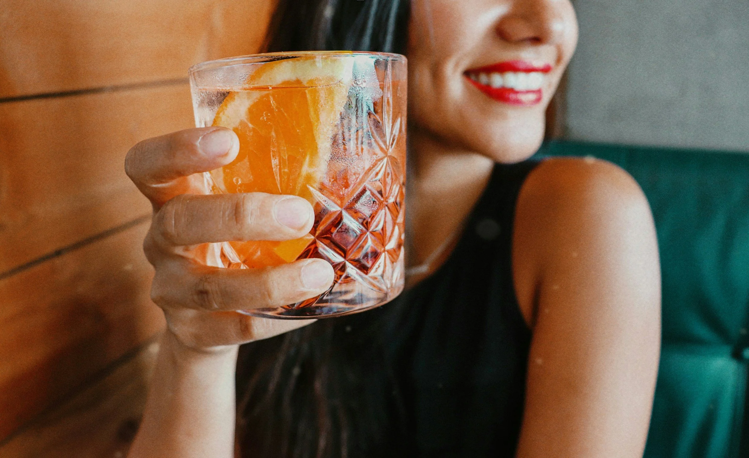 woman holds up a drink