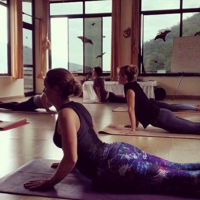 Jess from Jess Evans Yoga performs cobra pose while taking part in an accessible yoga class