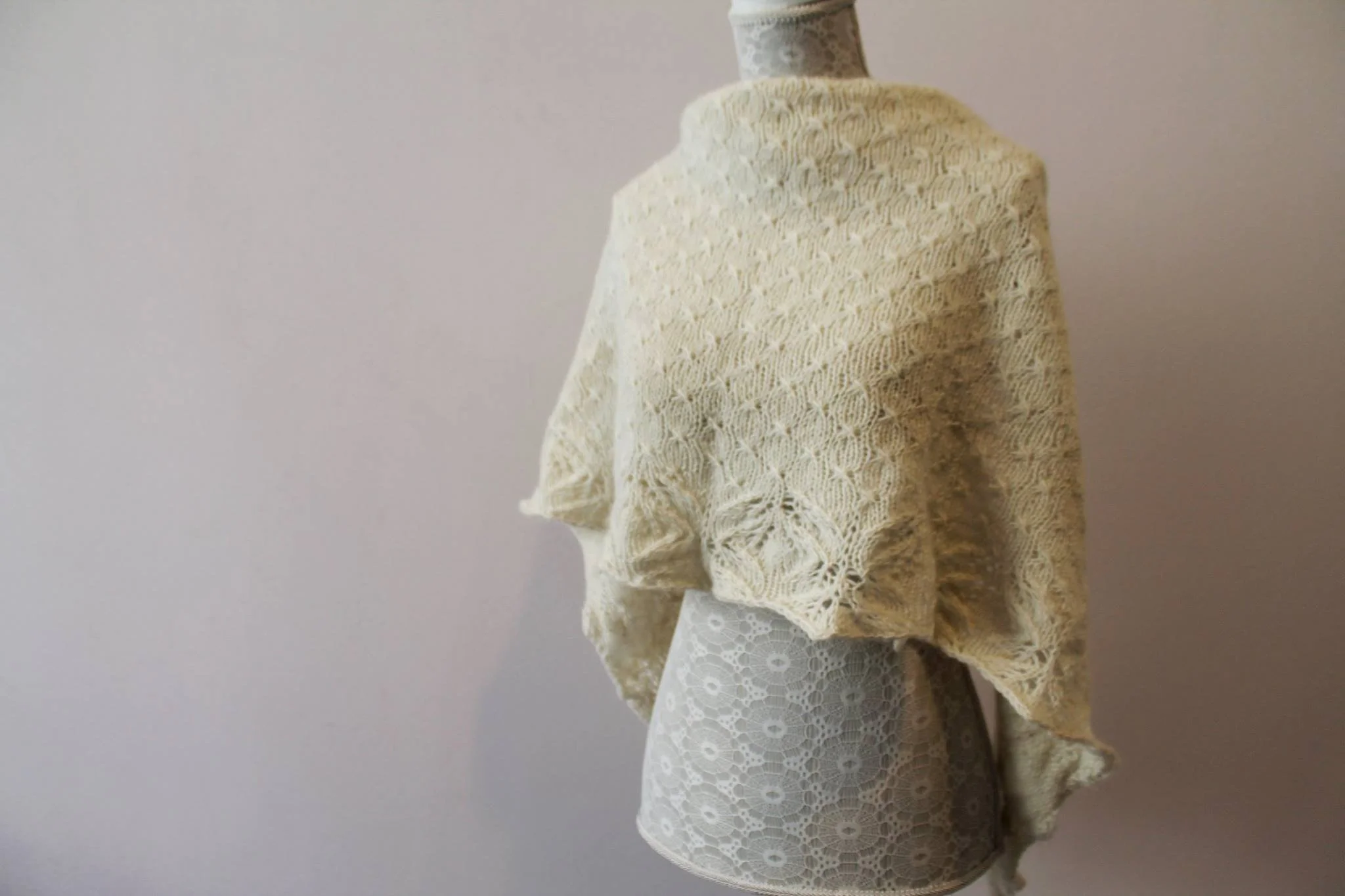 Close-up of a mannequin dressed in a layered vintage-style outfit with lace and knit fabric in light tones. Made at Monte Frio Alpacas. 