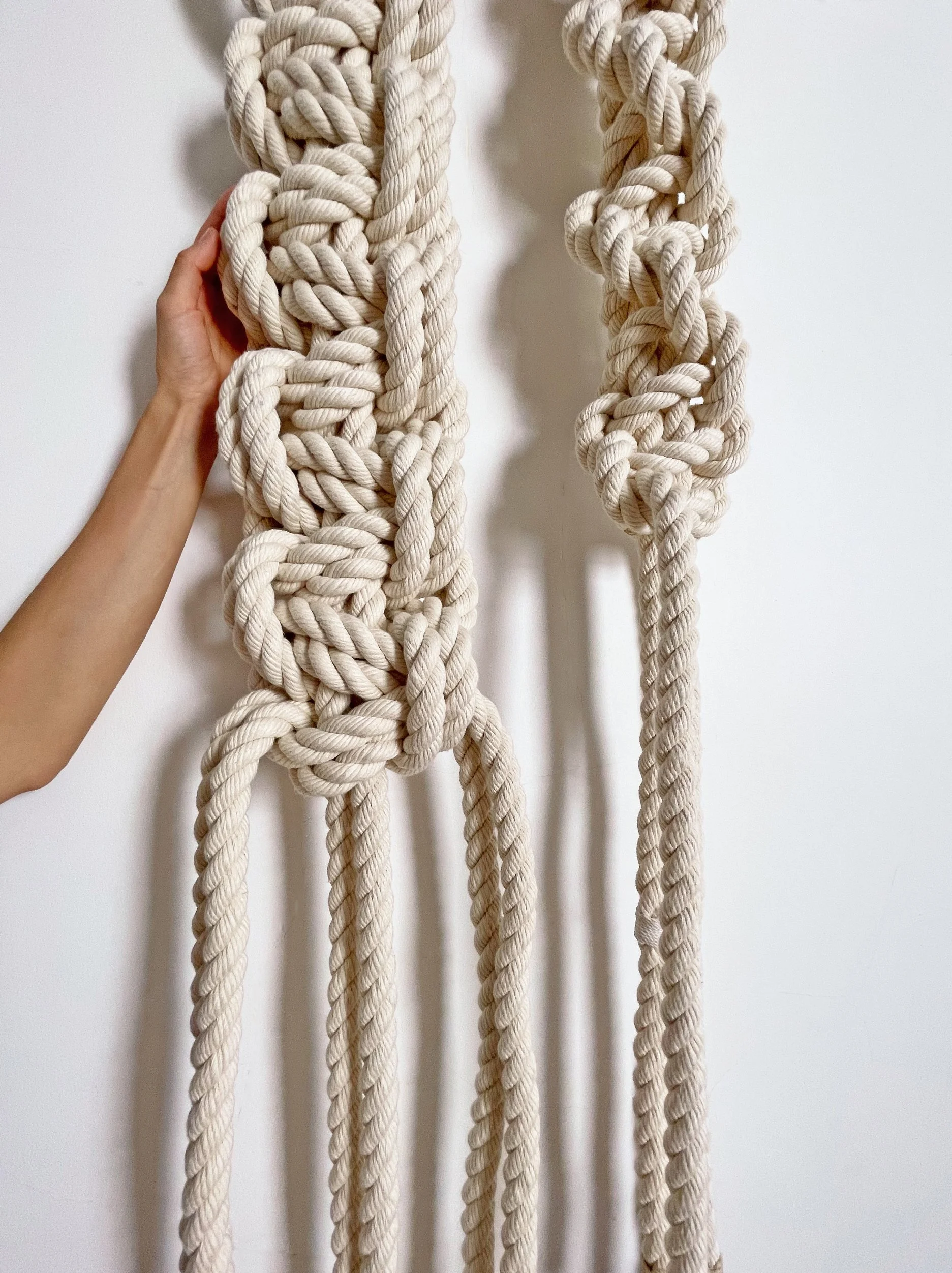 Detailed close-up of thick nautical fiber art knots showing the texture of organic cotton cord and intricate beeswax coated whipping twine wrapping
