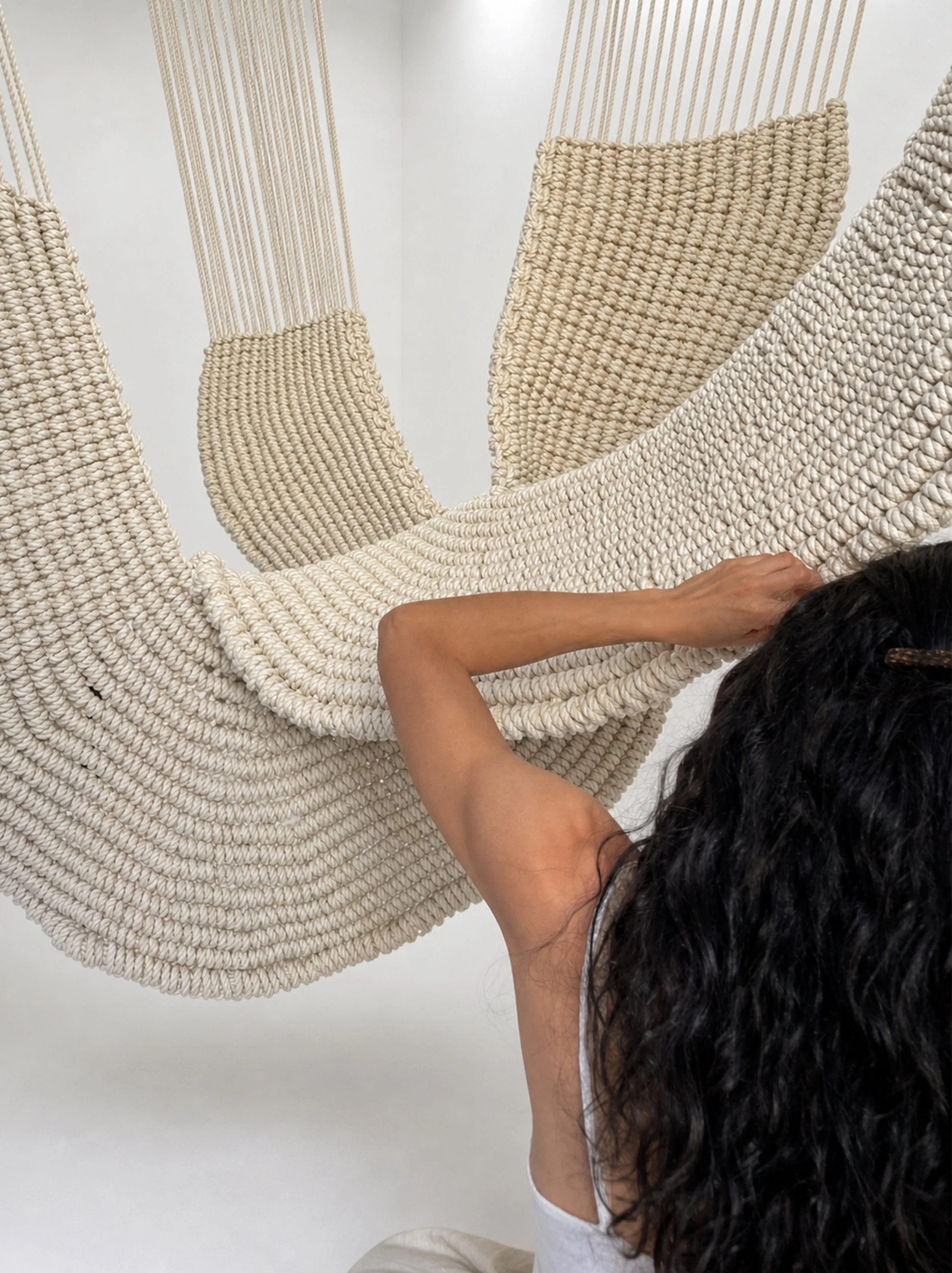 Maeve Pacheco with an extra-large hanging rope sculpture made from hand-knotted cotton rope