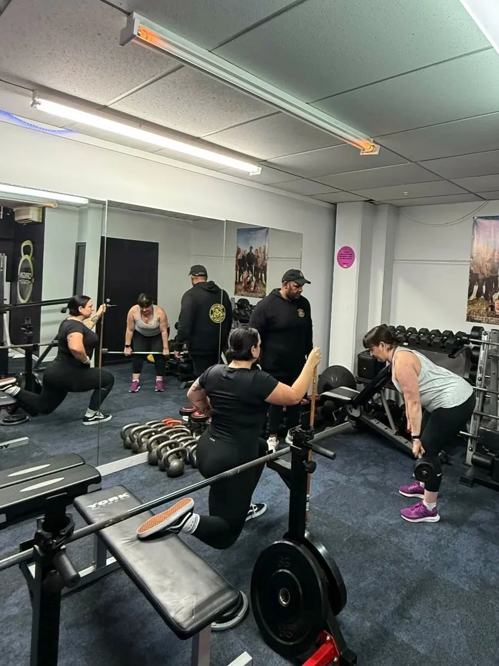 Women exercising with weights in a gym.