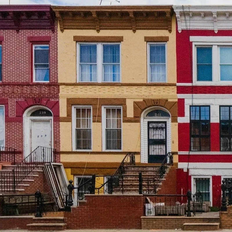 Yellow rowhome with red houseson each side