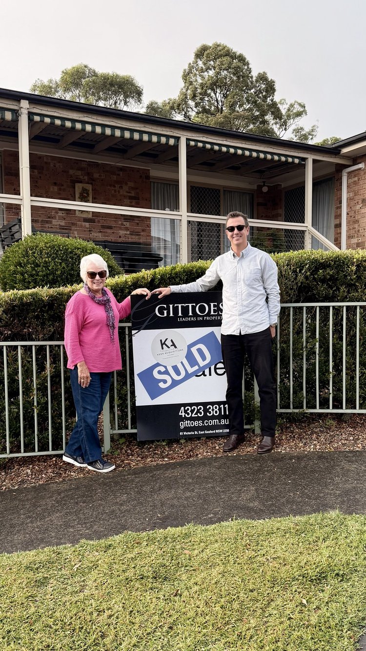 Mitch Keen with a happy buyer next to the sold sign