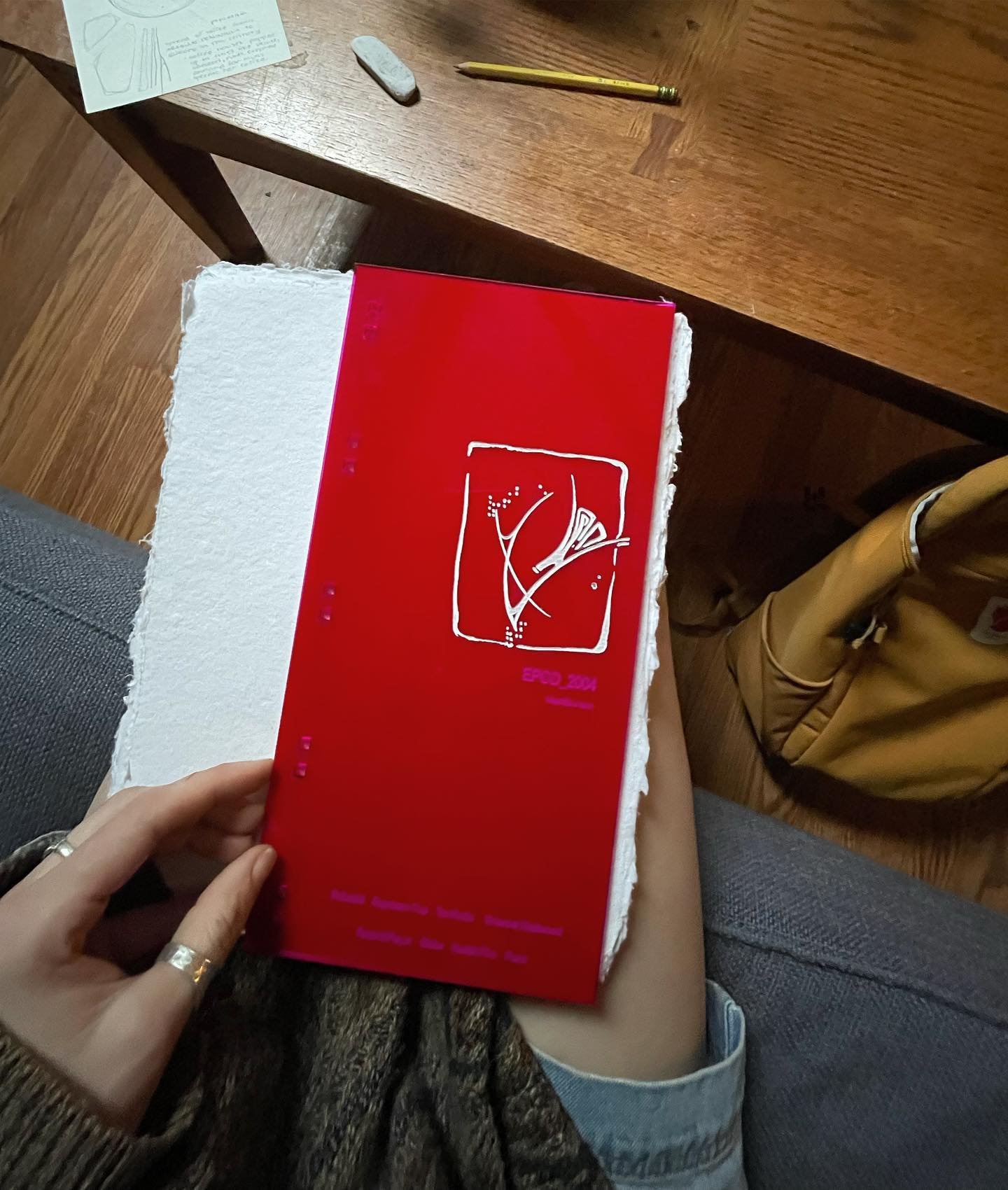 some pages from a book of products made from acrylic, red zip ties, and paper made from recycled tee shirts.