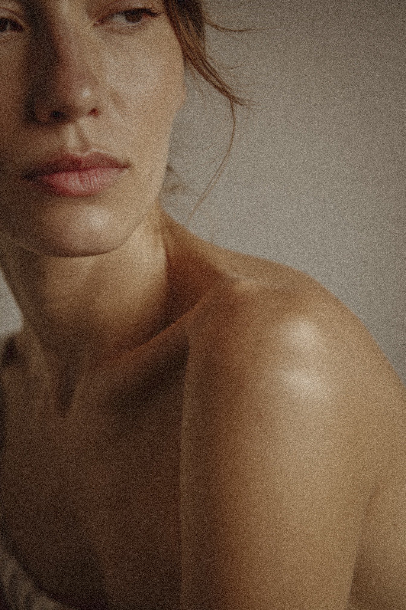 A close-up photograph of a woman with light skin and brown hair, showing part of her face and shoulder.