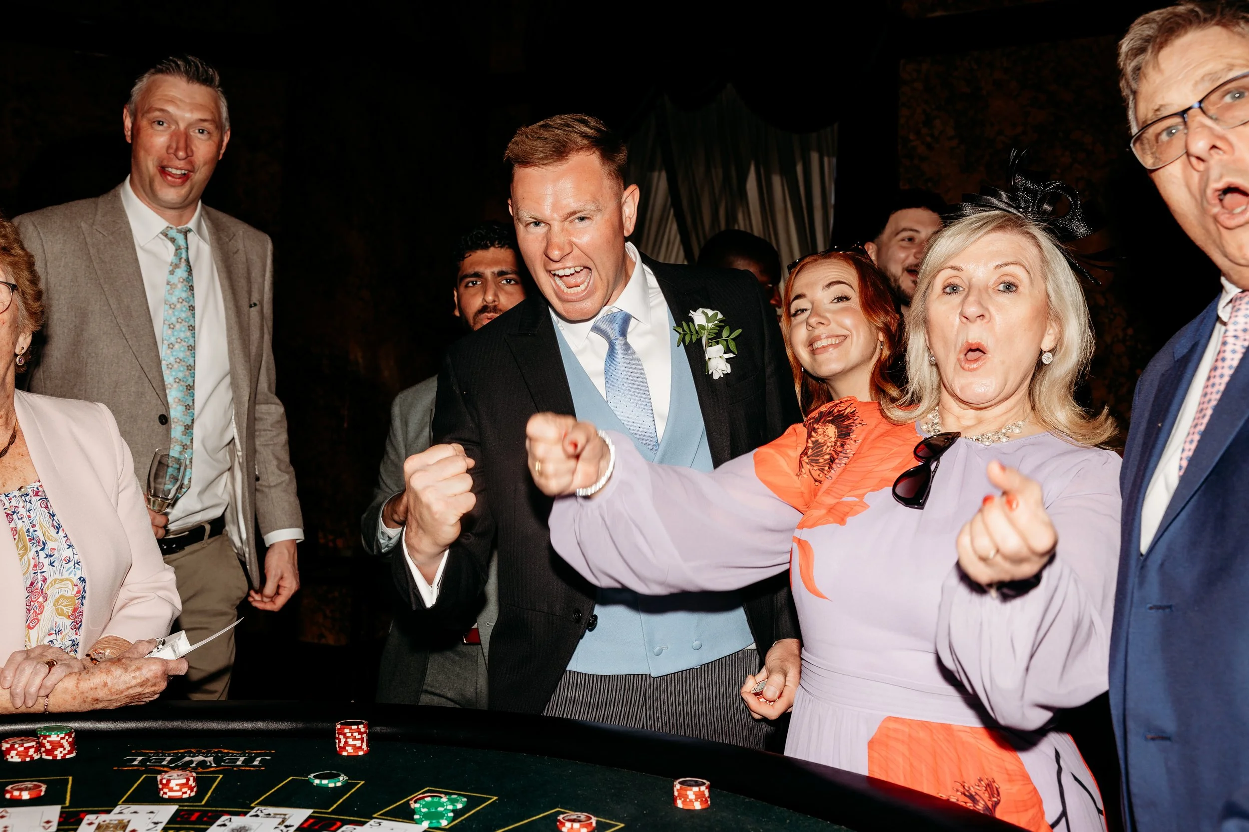 Group of people at a casino table playing poker, with chips and cards visible at Goodwood Estate, Sussex.
