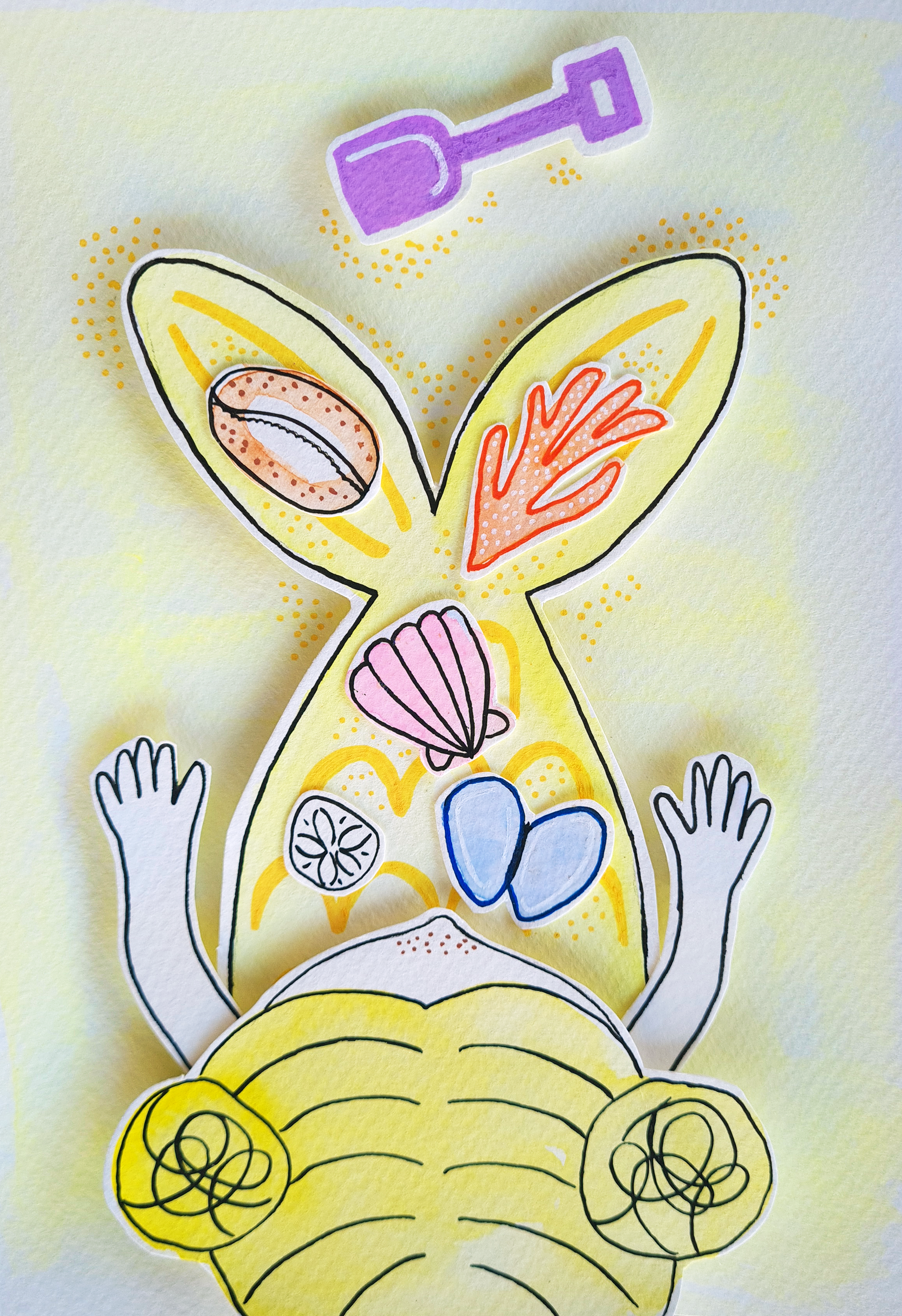 Colourful drawing of a sandcastle mermaid with various cut-out paper pieces representing shell items on top of the mermaid tail, placed on a light background, with a purple shovel icon above.