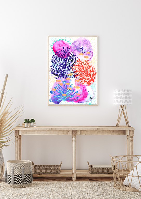 Framed colourful abstract artwork of coral and sea life hanging above a wooden console table in a minimalist living room.