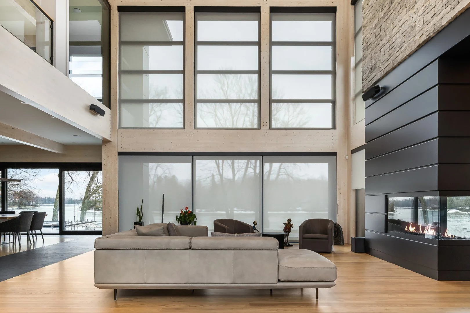 Living room with automated shades on the windows to cover sunlight add privacy and protect furnishings and reduce he