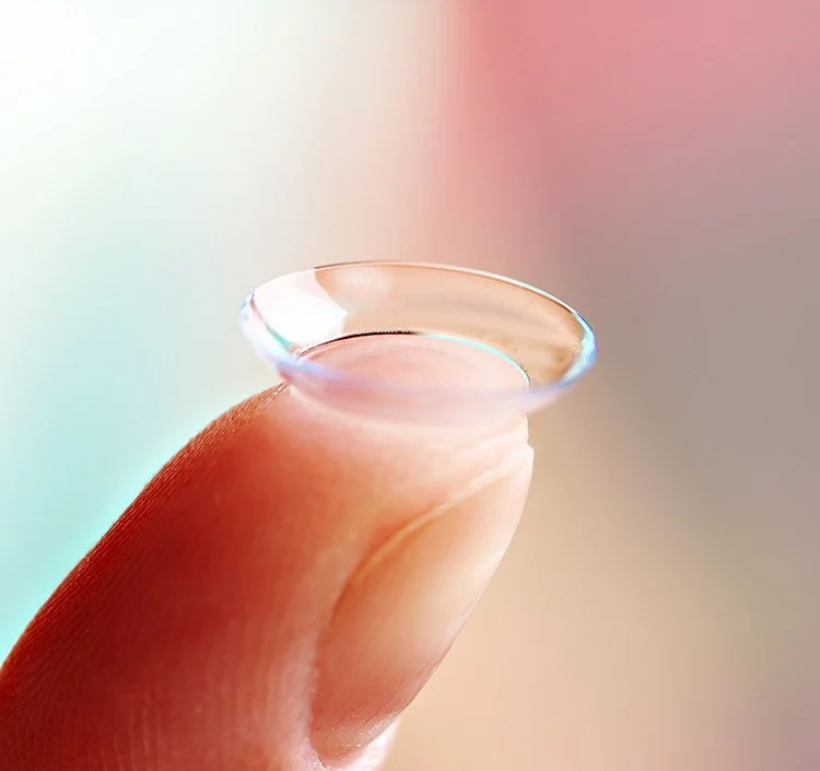 Person putting contact lenses to their right eye