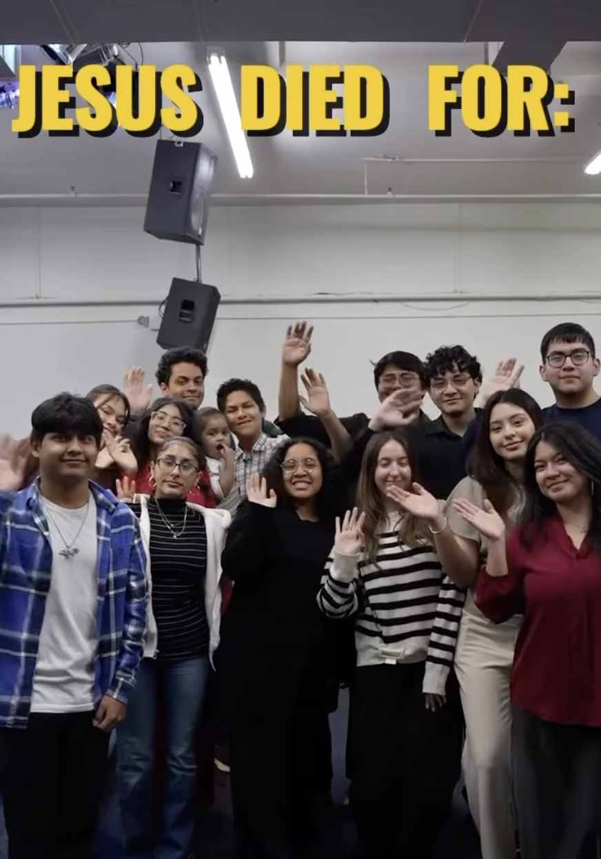 Grupo de personas sonriendo y saludando en un ambiente interior, con un texto en la parte superior que dice 'Jesús murió por:'.
