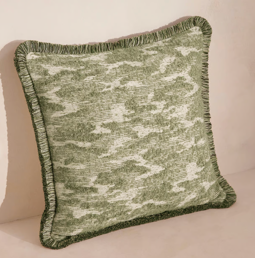 Textured cushion by Soho Home with abstract pattern on one side and plain velvet on the other.