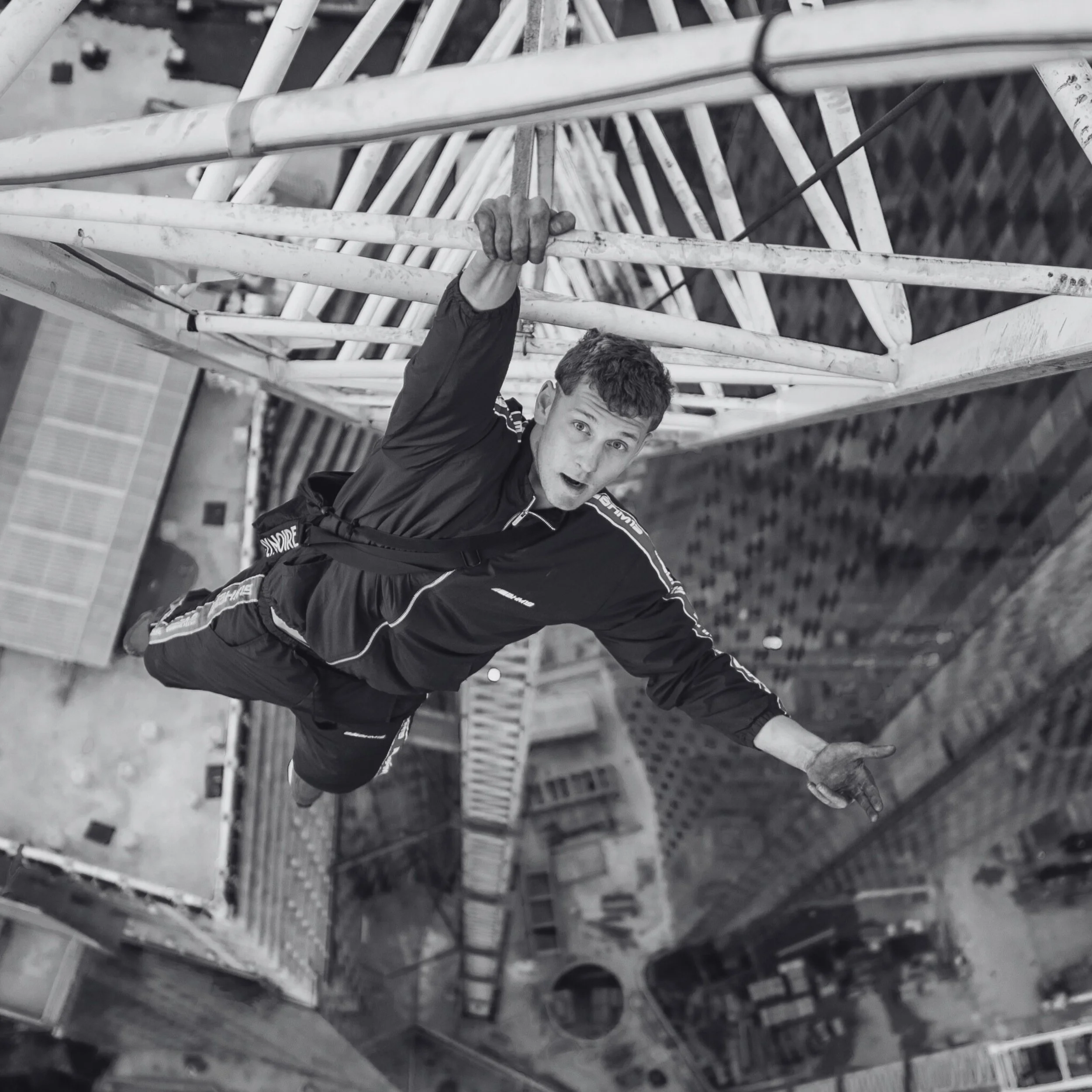 George is a white man wearing a tracksuit, literally hanging from the Shard in London by one hand.