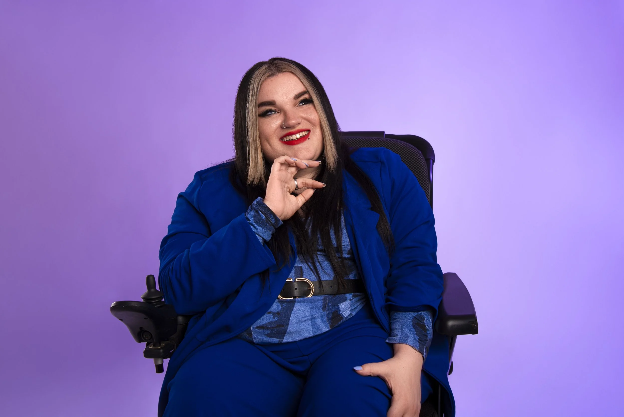 Founder Kelly in her powerchair, wearing a blue suit
