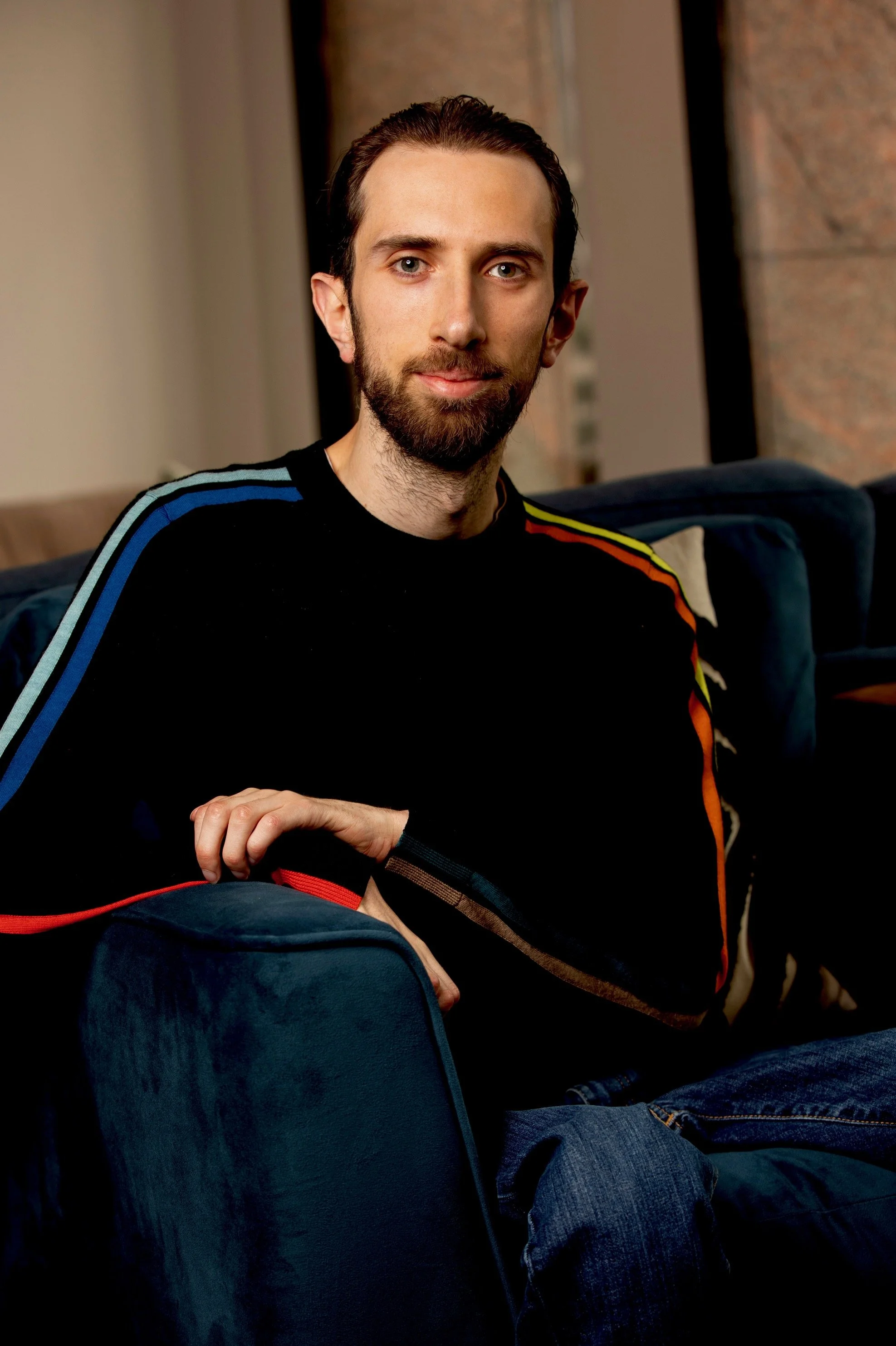 Stefan sat on a sofa looking at the camera