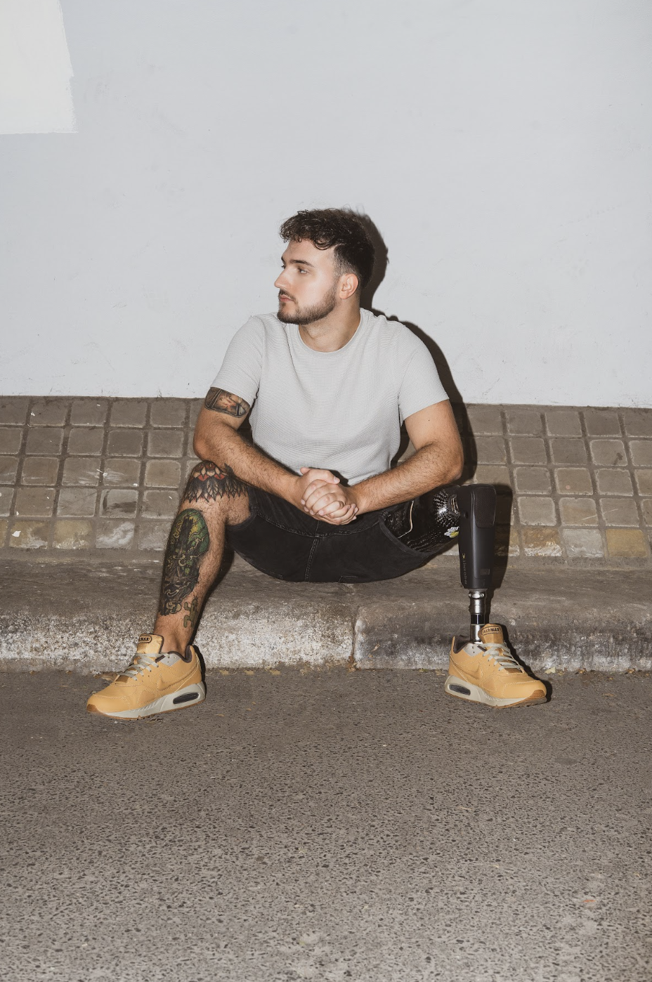 Portrait of Aniello sitting on curb