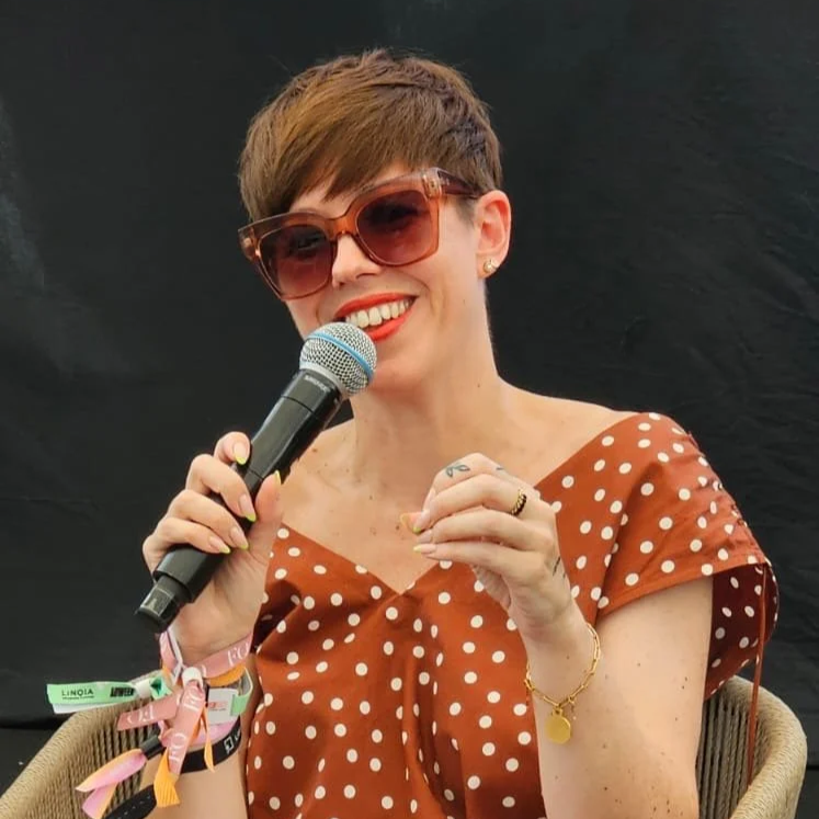 Emma holding a microphone, smiling