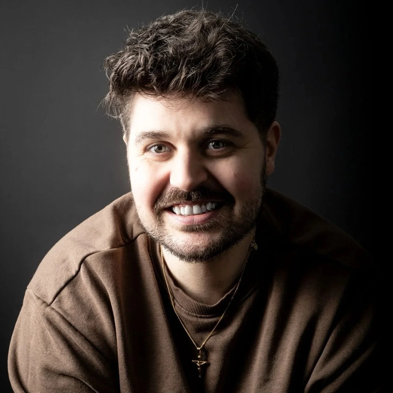 Nathan is a white male with short brown hair, trimmed facial hair, wearing a brown t.shirt.