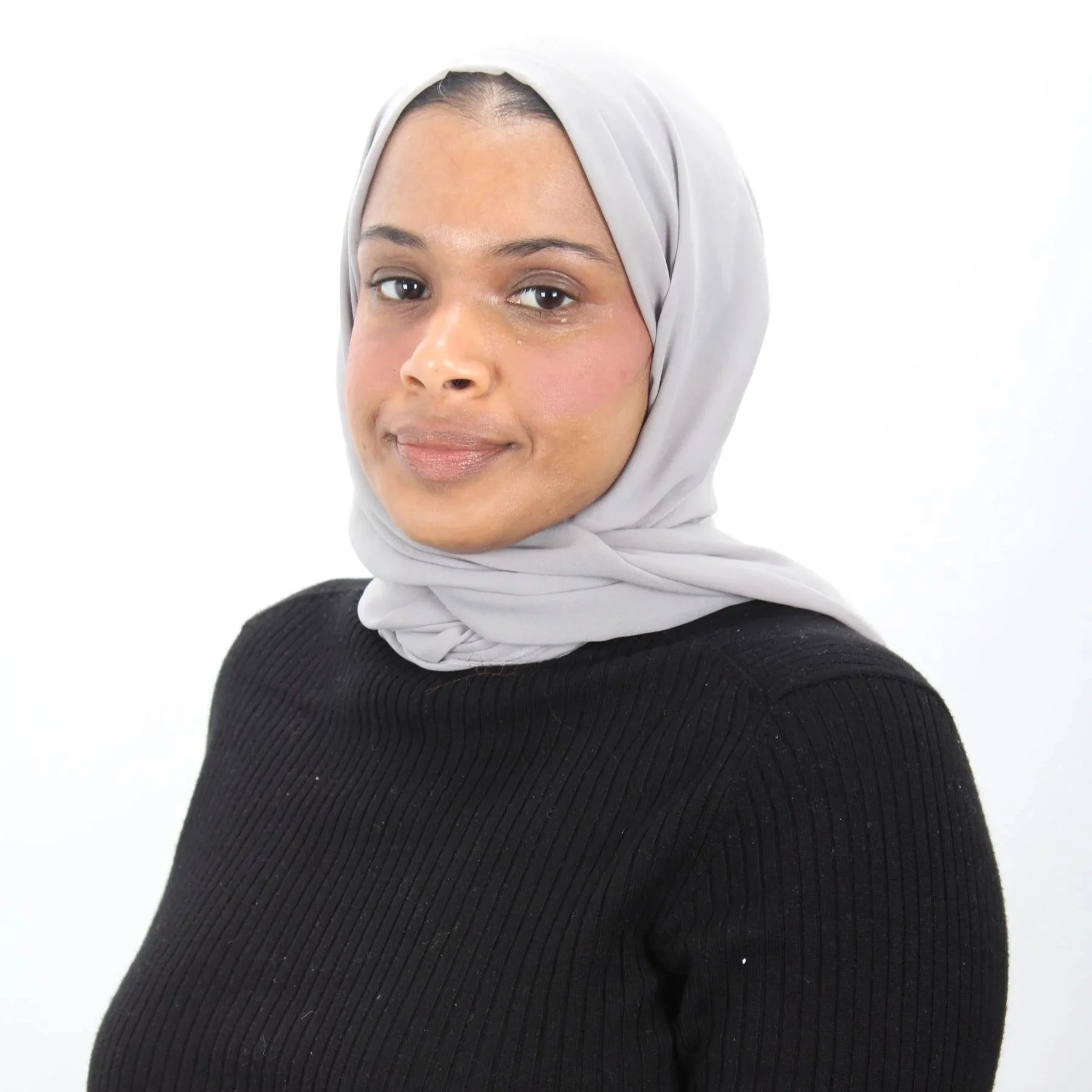 Umi is a brown woman wearing a grey hijab and a black top