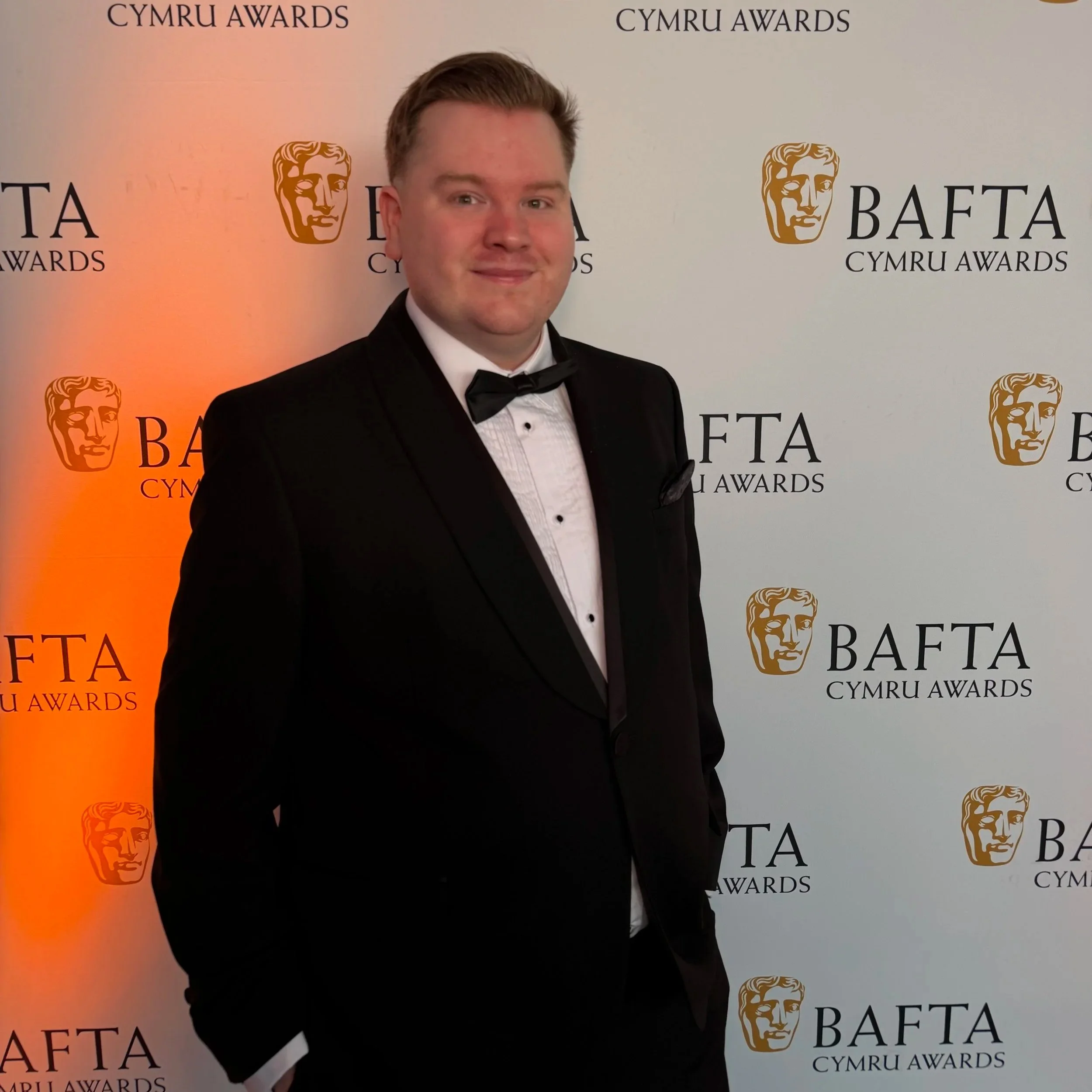 Nicholas posing in a black suit at the Welsh BAFTAs in 2025