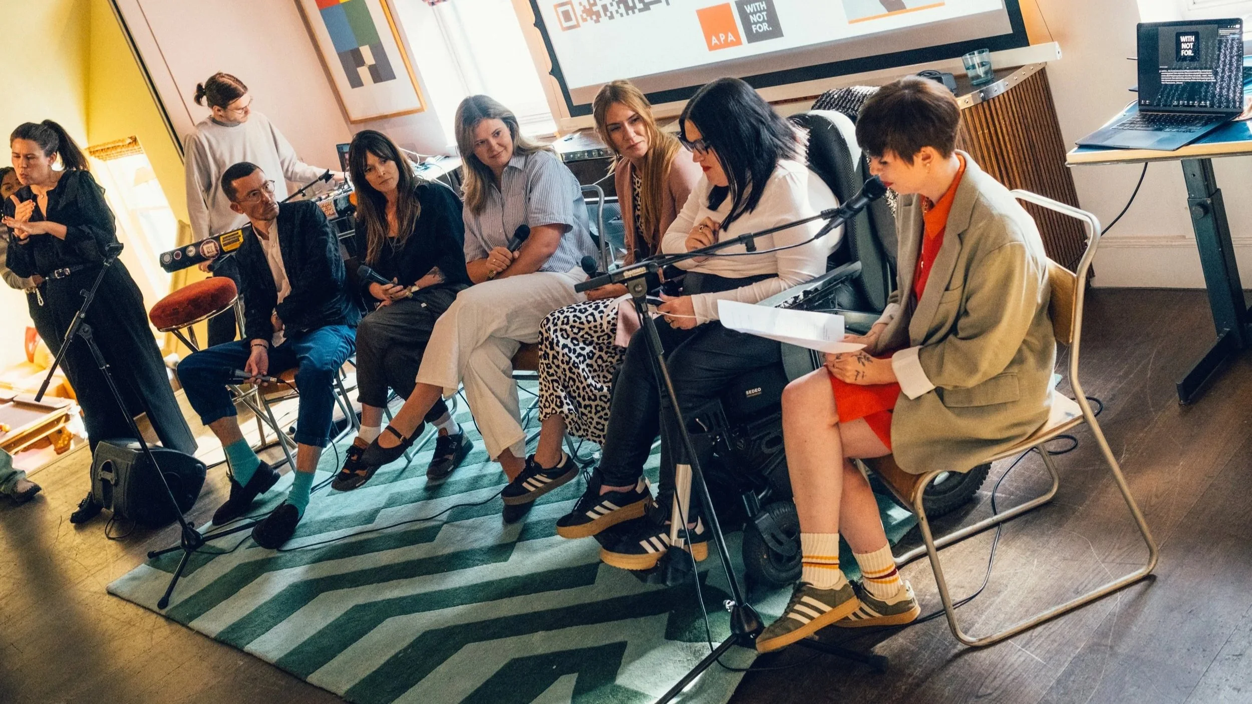 The six panellists, seated on stage with a BSL interpreter stood on the left.