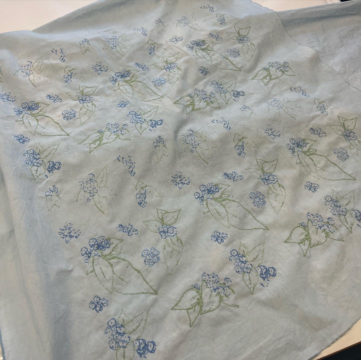Fully embroidered floral repeat on dyed blue cotton
