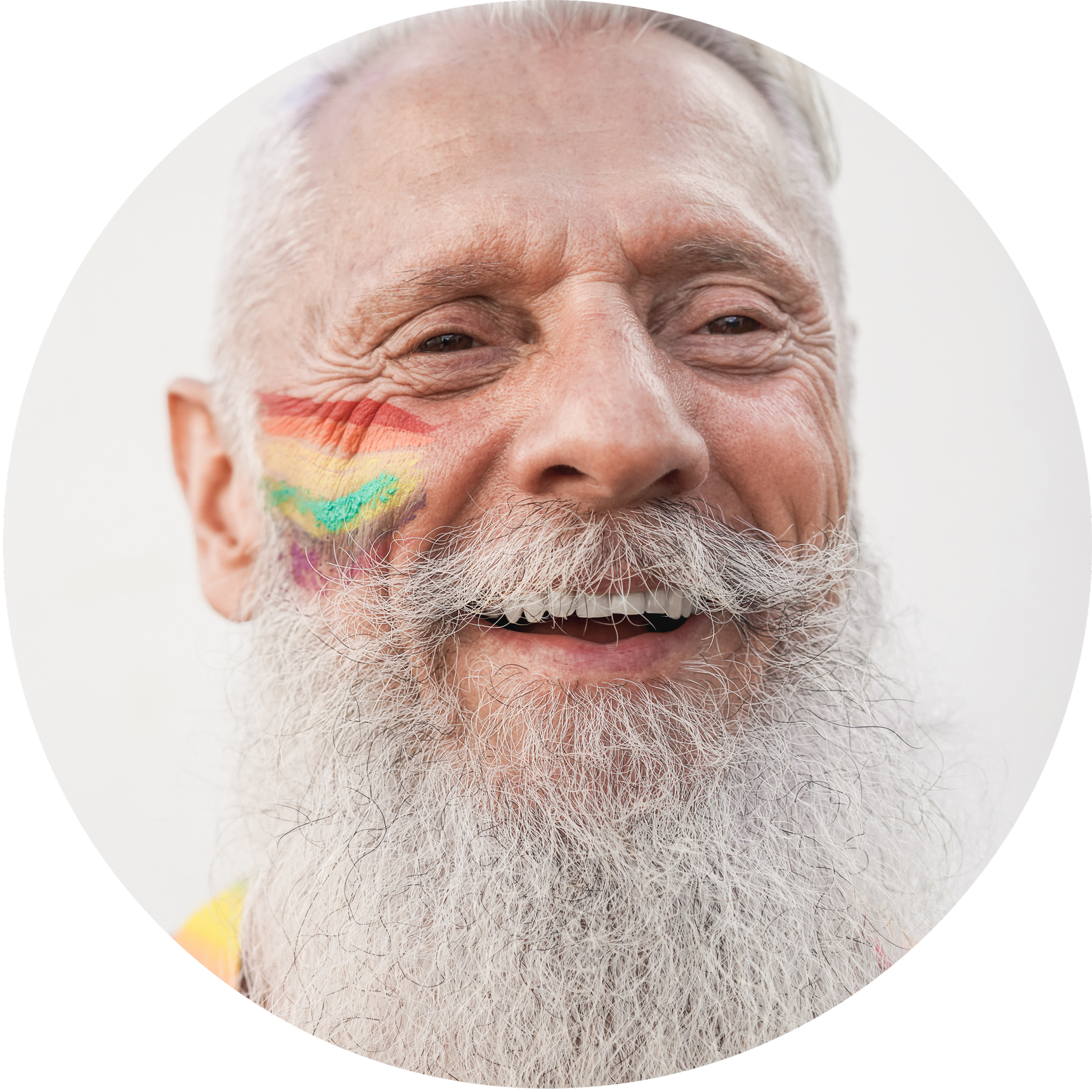 Close-up of a smiling older man with a rainbow painted on his cheek.