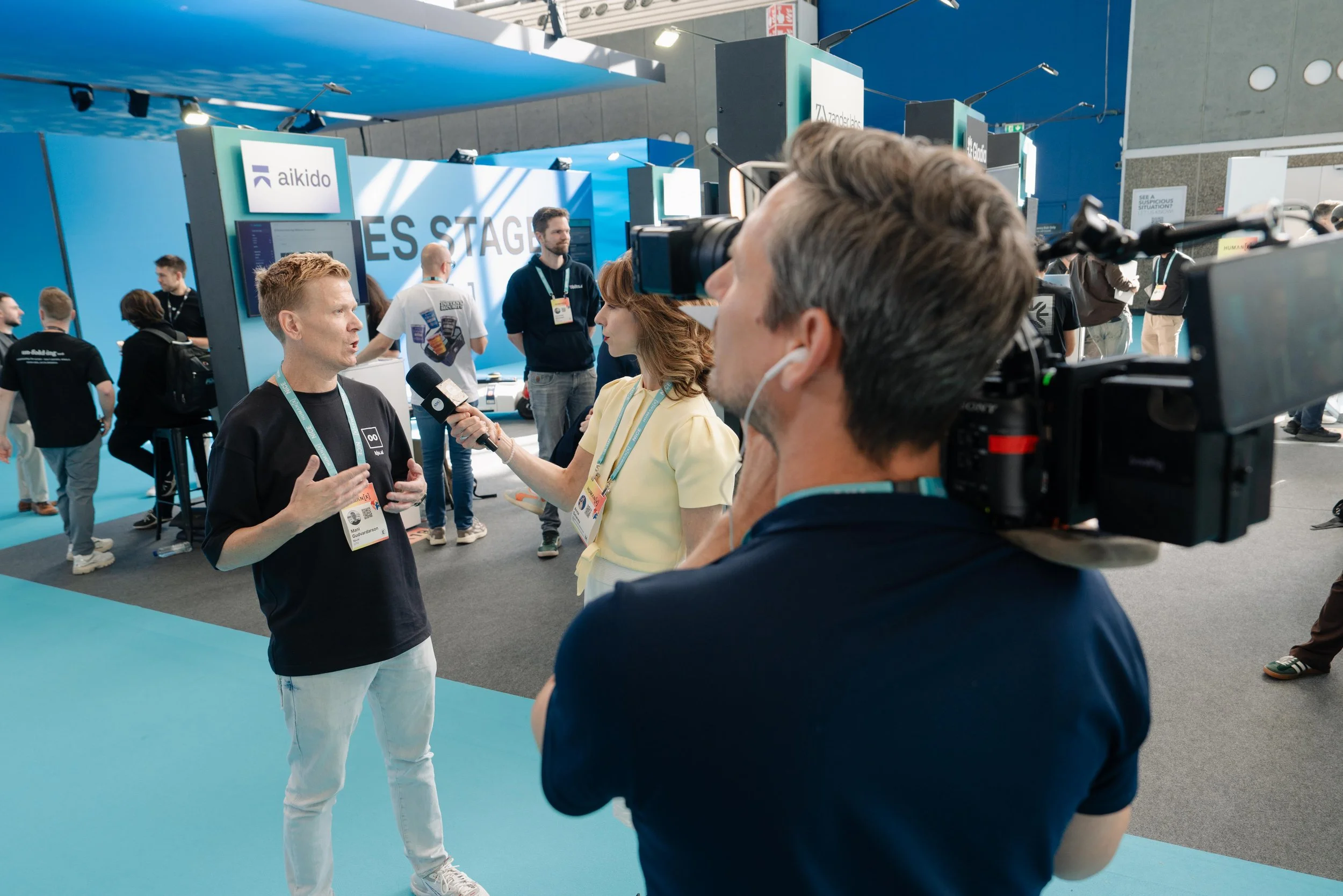 Conference videographers filming expo floor interviews in Amsterdam