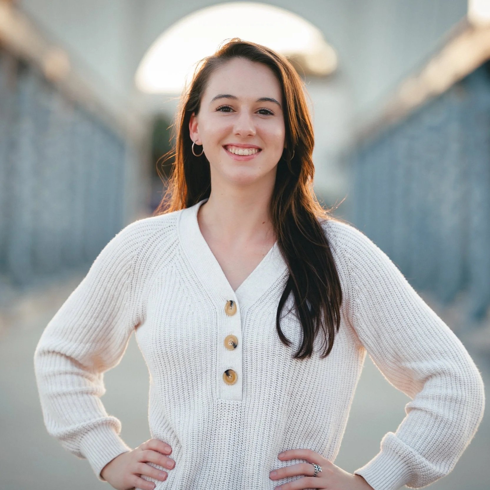 Female real estate agent posing in front of the Waco suspension bridge going across the Brazos River.